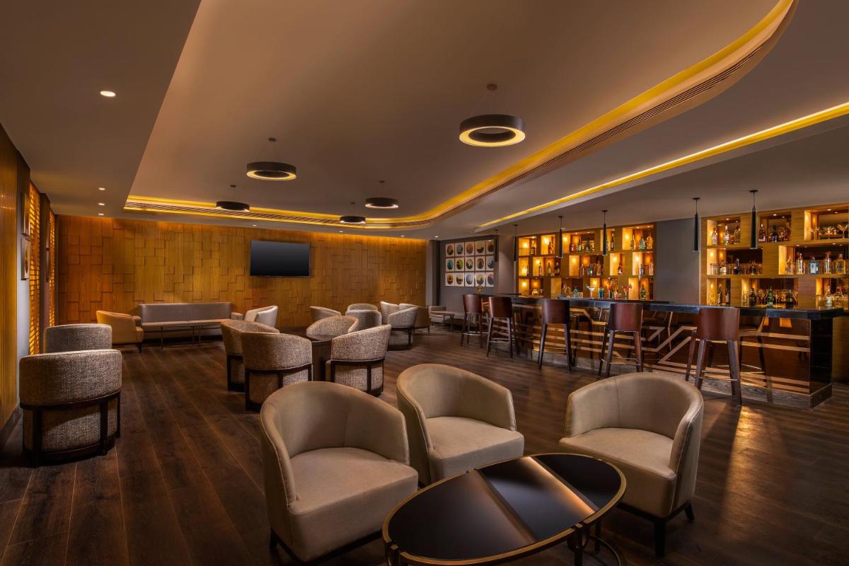 a hotel lobby with chairs and a bar and books at Holiday Inn Agra MG Road an IHG Hotel in Agra