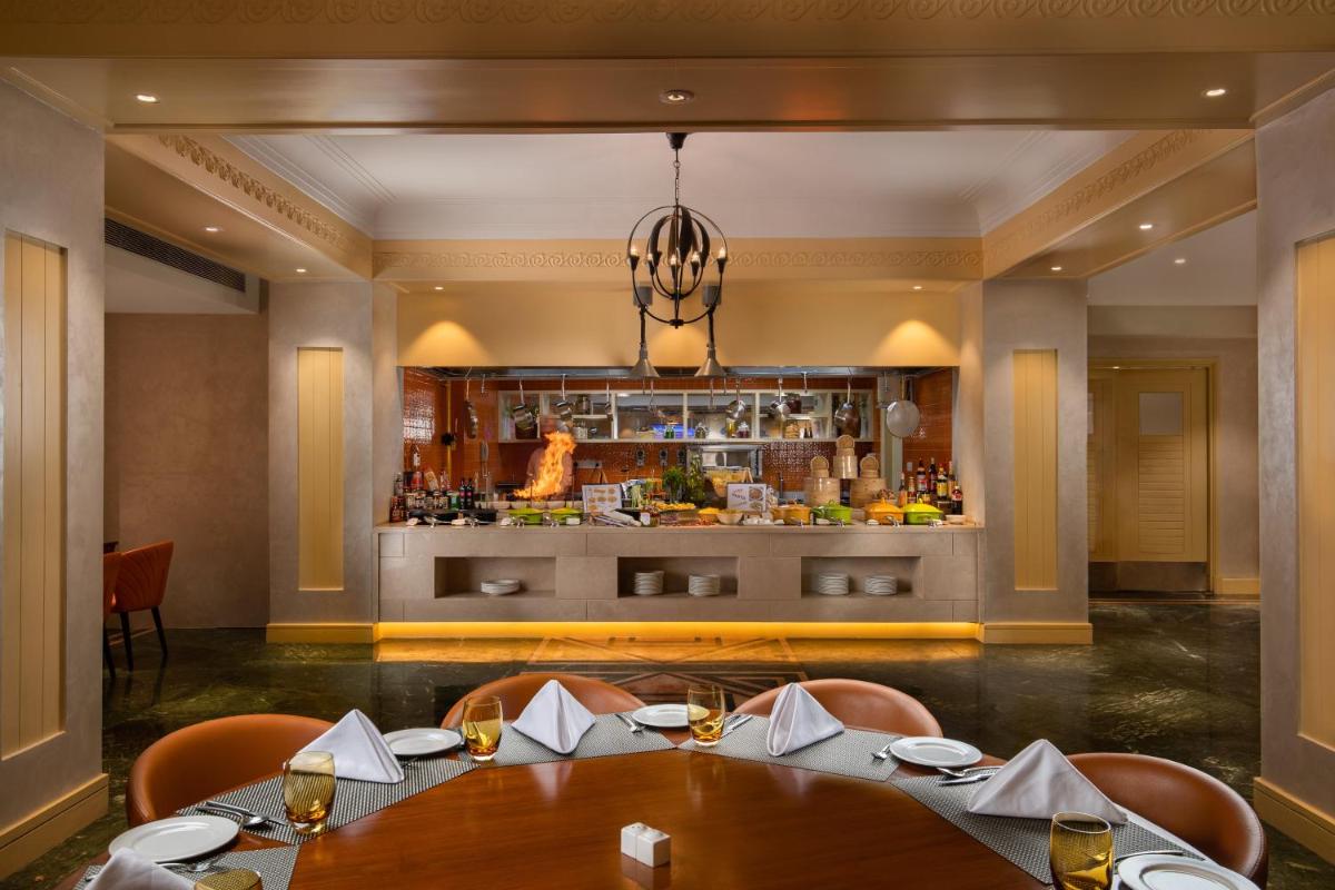 a restaurant with a table and chairs and a bar at Holiday Inn Agra MG Road an IHG Hotel in Agra