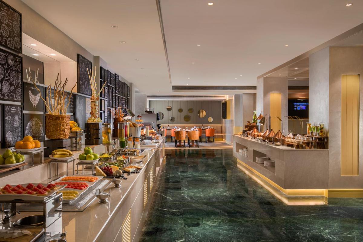 a buffet line in a hotel with food on display at Holiday Inn Agra MG Road an IHG Hotel in Agra