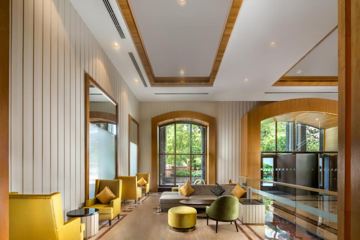 a living room with yellow chairs and a couch at Holiday Inn Agra MG Road an IHG Hotel in Agra