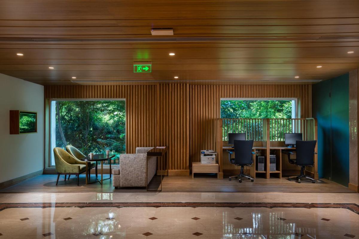 a lobby with a desk and chairs and a table at Holiday Inn Agra MG Road an IHG Hotel in Agra