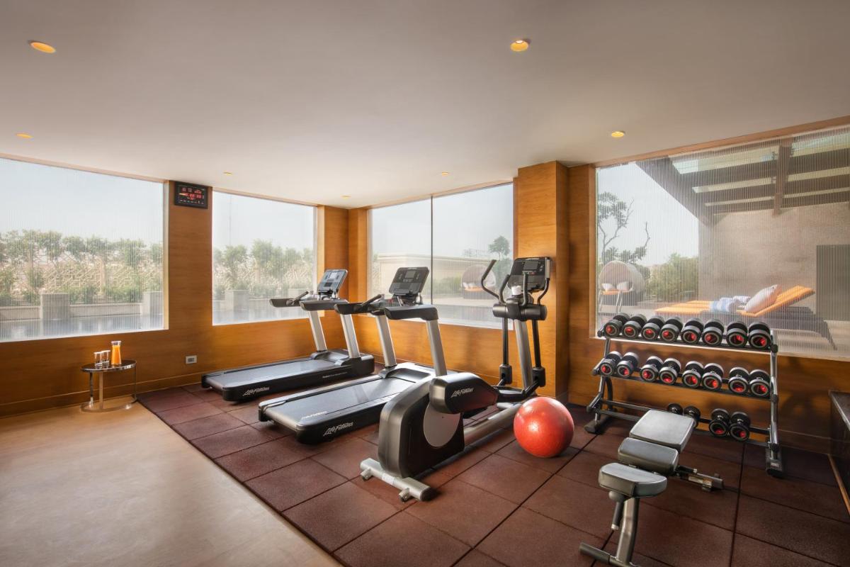 a gym with treadmills and exercise equipment in a room at Holiday Inn Agra MG Road an IHG Hotel in Agra