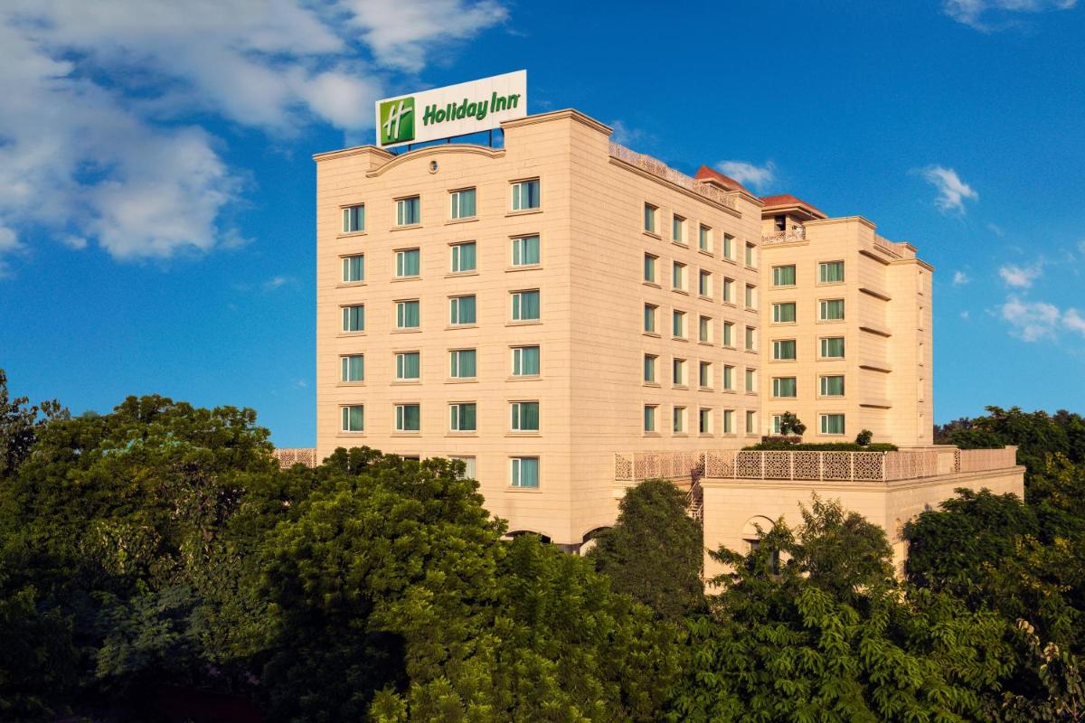 a building with a sign on top of it at Holiday Inn Agra MG Road an IHG Hotel in Agra