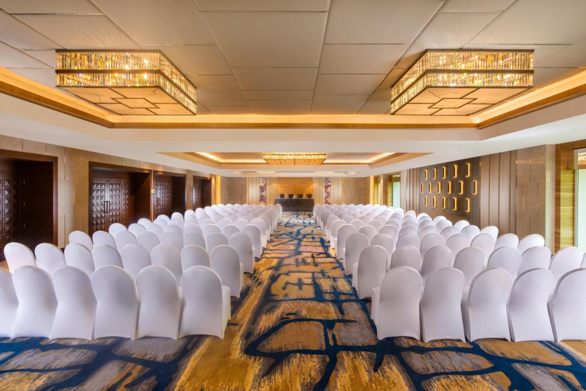 a row of white chairs in a conference room at Holiday Inn Agra MG Road an IHG Hotel in Agra