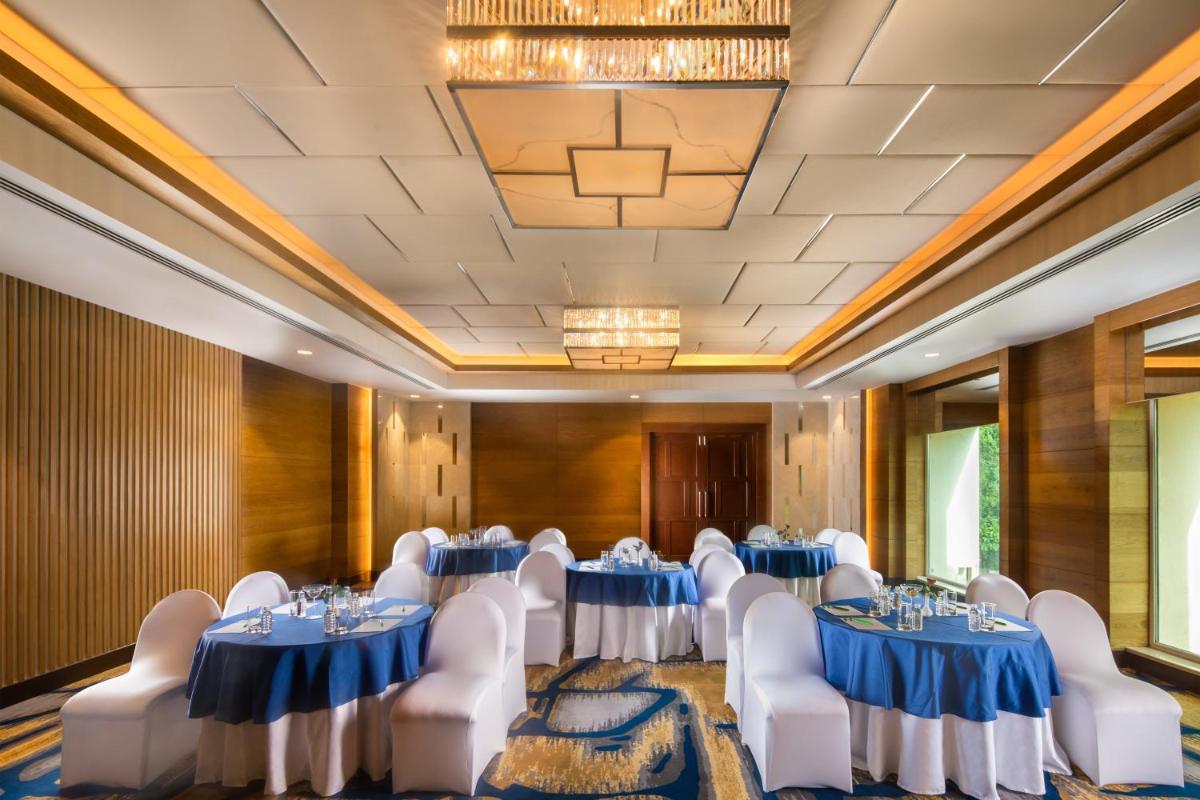 a banquet room with blue and white tables and chairs at Holiday Inn Agra MG Road an IHG Hotel in Agra
