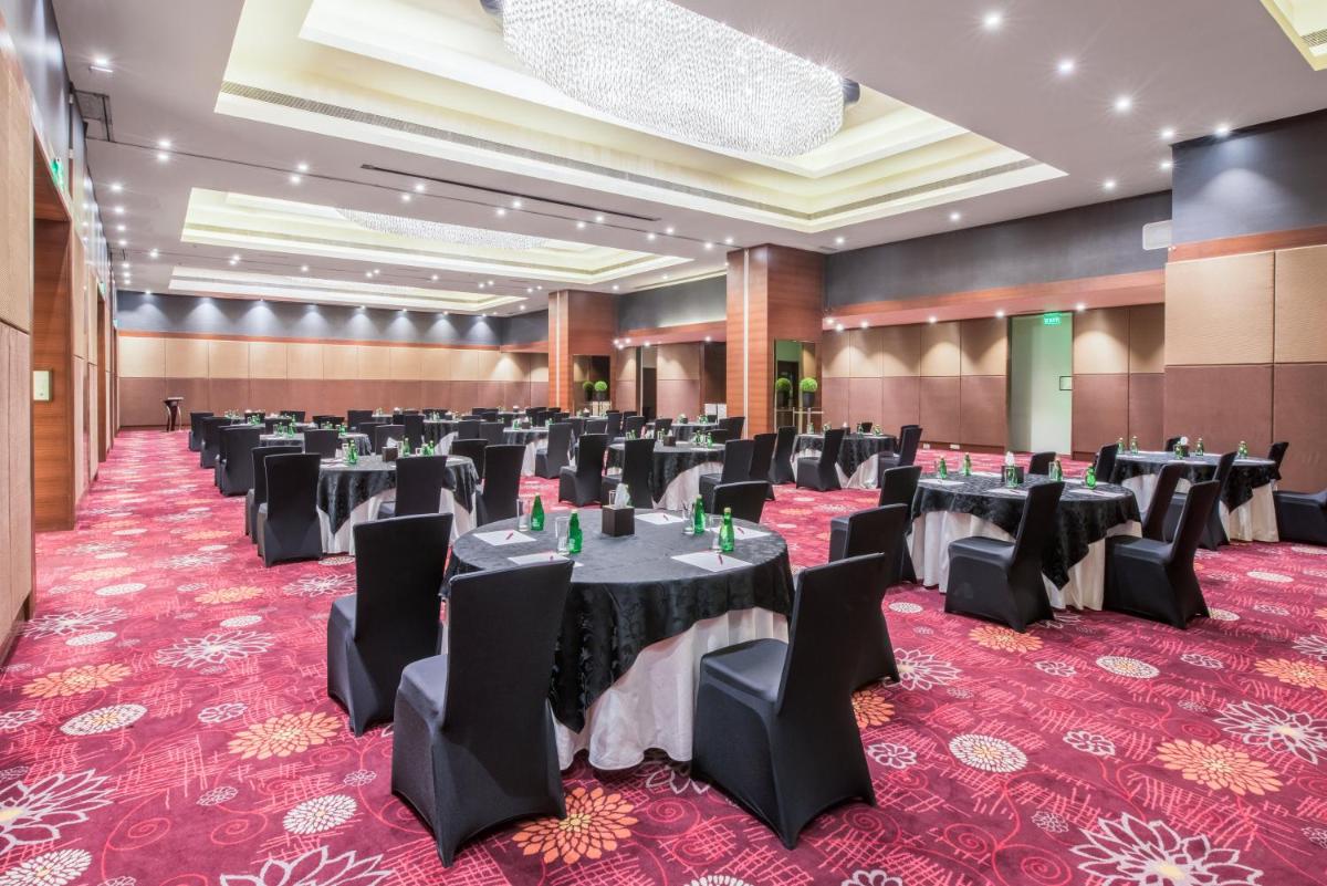 a large banquet hall with black tables and chairs at Crowne Plaza Ahmedabad City Centre by IHG in Ahmedabad