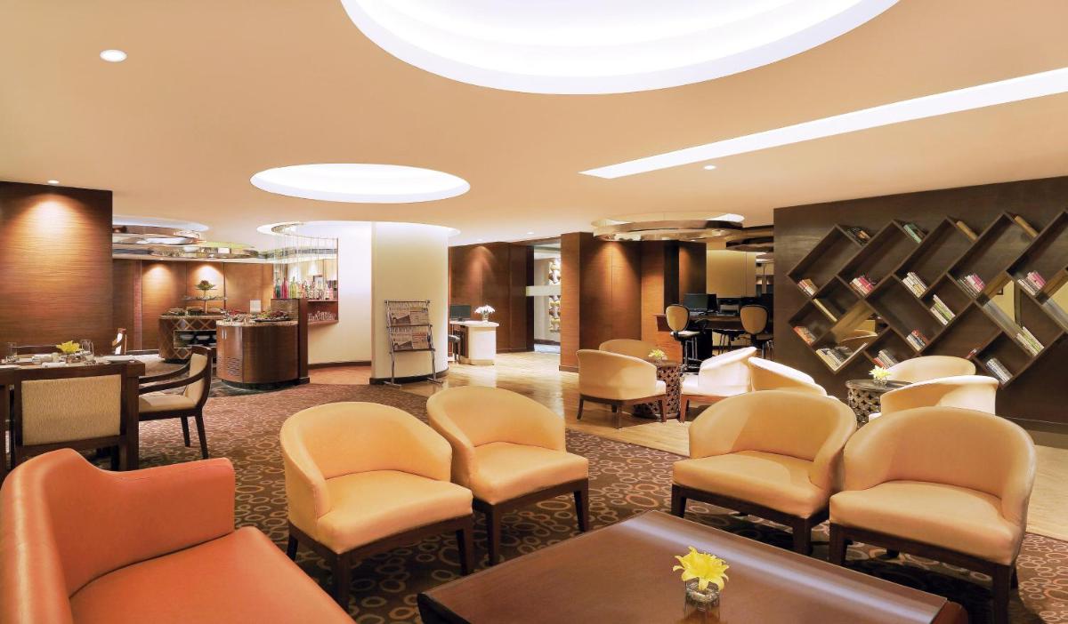 a waiting room with chairs and a barber shop at Crowne Plaza Ahmedabad City Centre by IHG in Ahmedabad