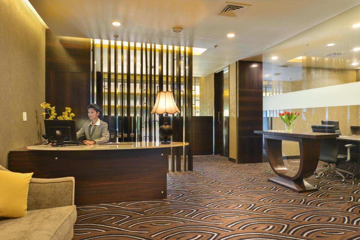 a woman sitting at a desk in a hotel lobby at Crowne Plaza Ahmedabad City Centre by IHG in Ahmedabad