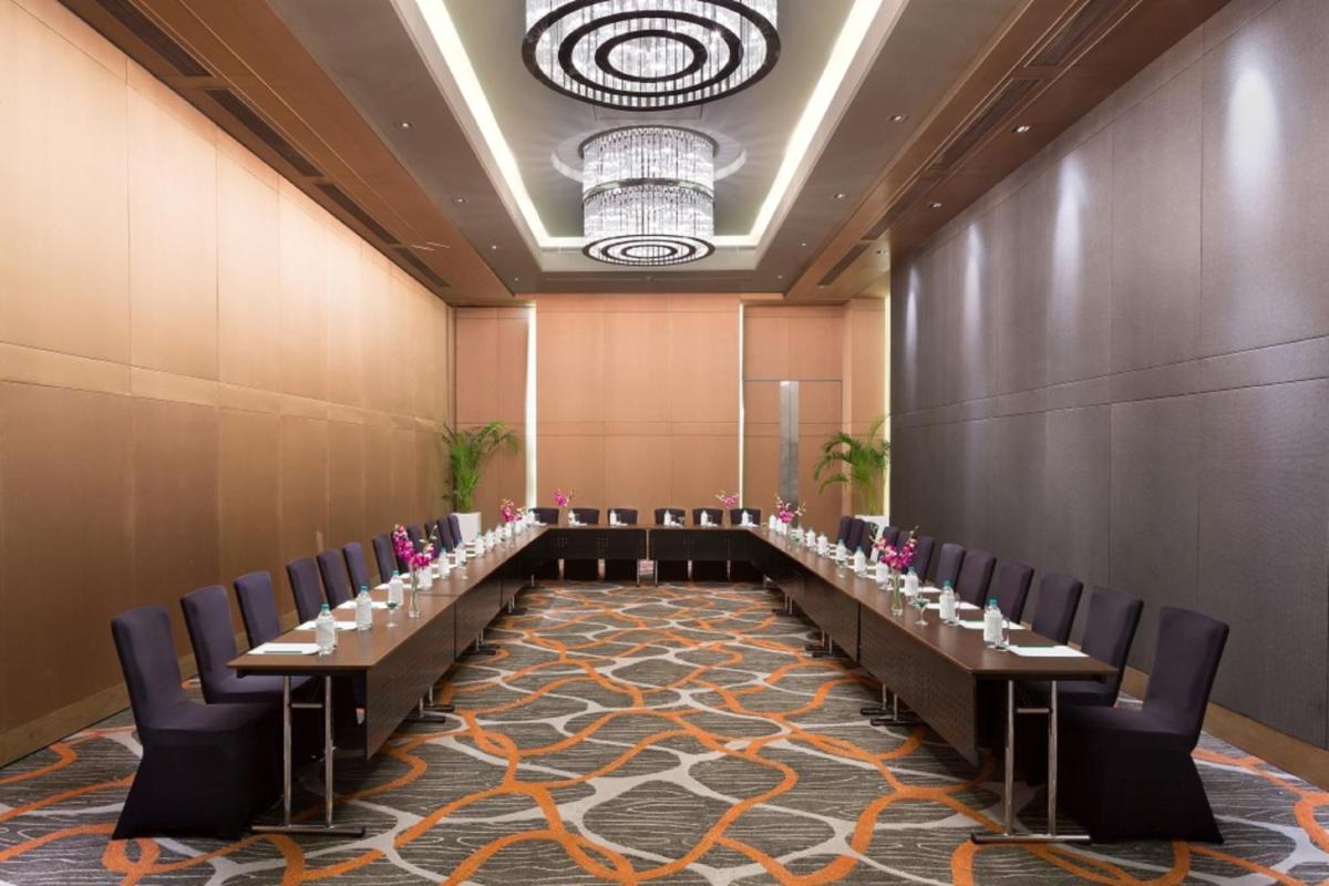 a row of tables in a room with chairs at Holiday Inn New Delhi Aerocity by IHG in New Delhi