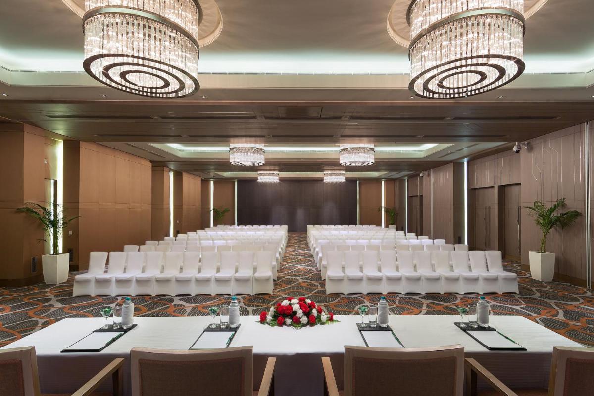 a banquet hall with white tables and chairs and chandeliers at Holiday Inn New Delhi Aerocity by IHG in New Delhi