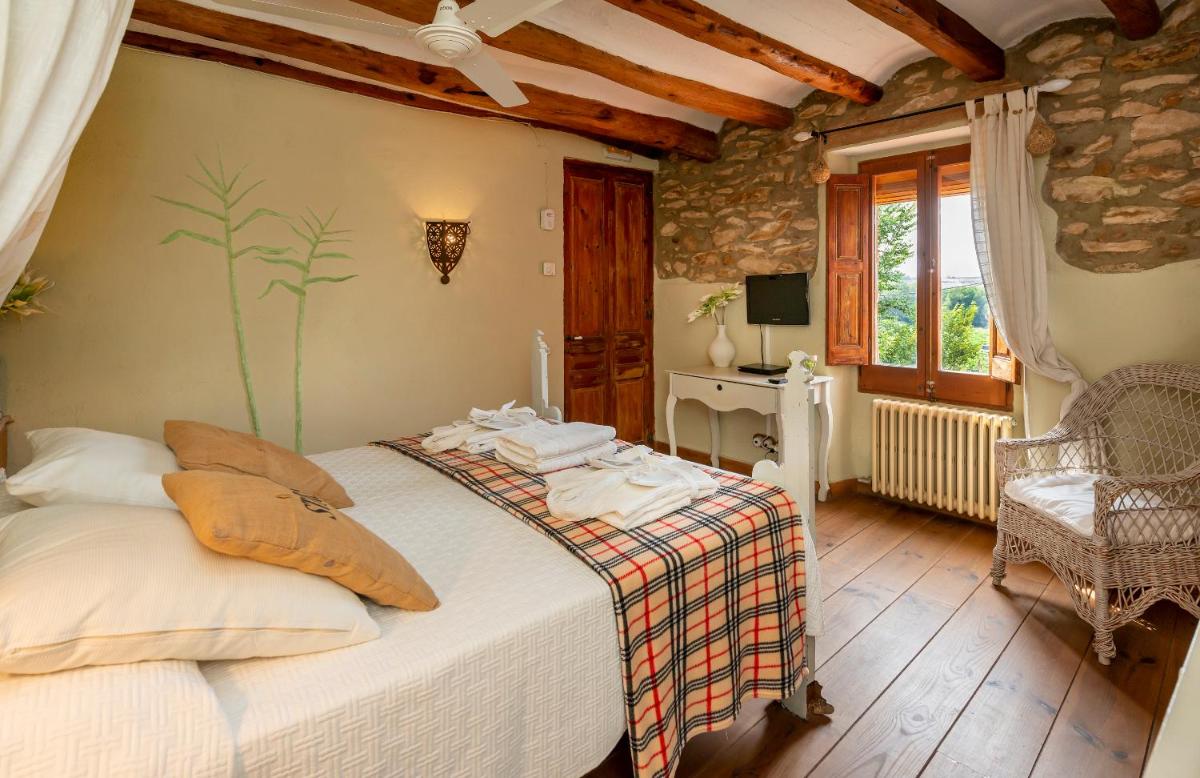 un dormitorio con una cama en una habitación en Les Vinyes Alojamiento Rural Boutique & SPA, en Vilardida 183 fotos más