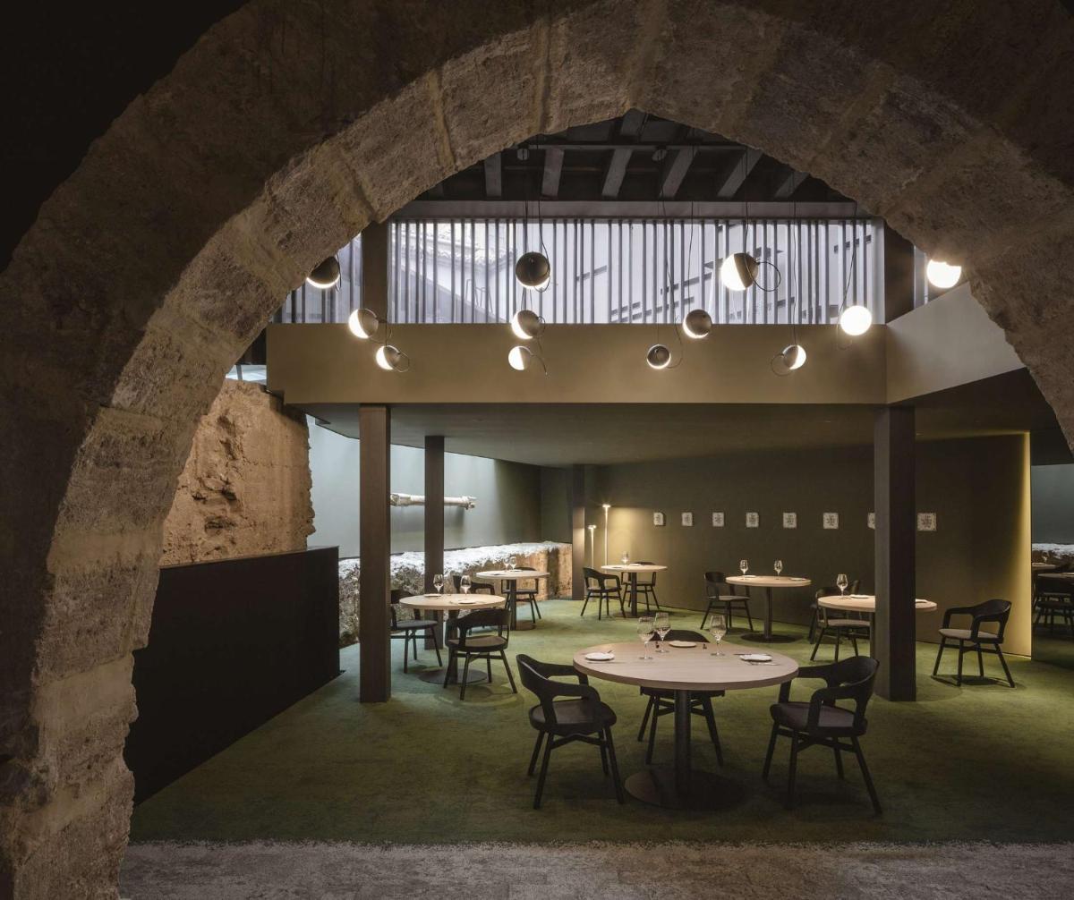un comedor con mesas y sillas y un arco en Caro Hotel, en Valencia