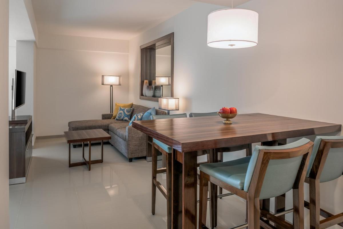 a kitchen and living room with a wooden table and chairs at The Residency Towers, Rameswaram in Rāmeswaram