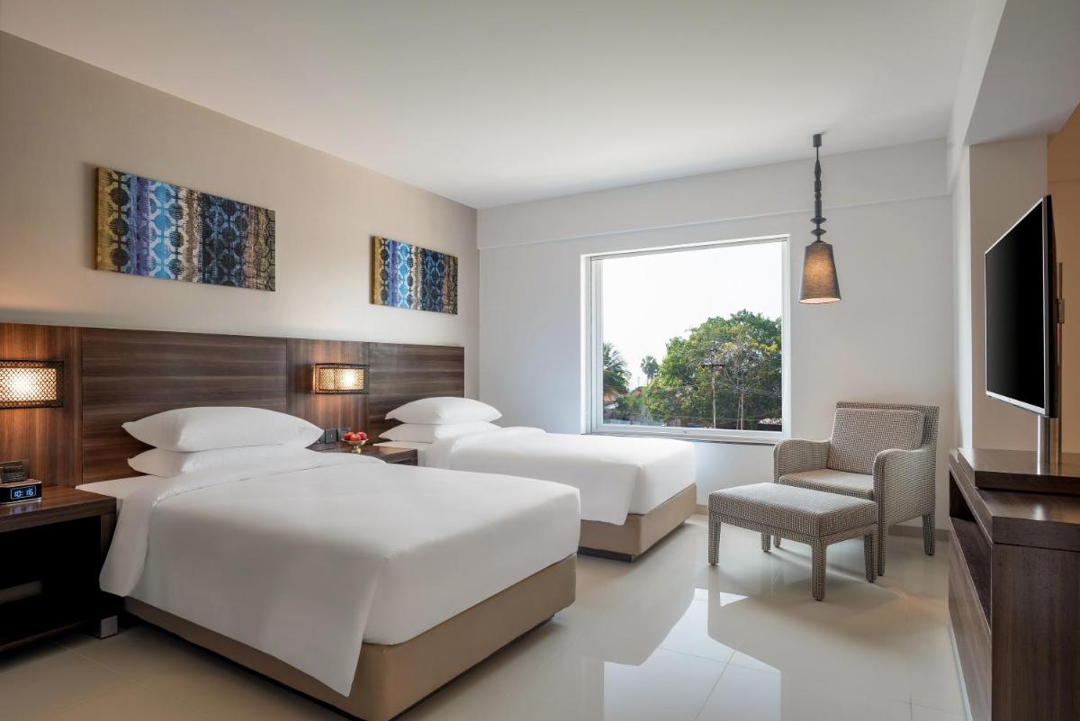 a bedroom with two beds and a flat screen tv at The Residency Towers, Rameswaram in Rāmeswaram