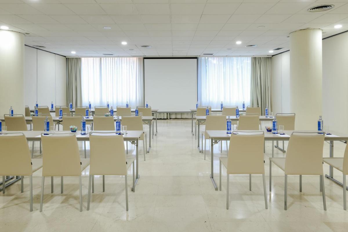 Una sala de conferencias con mesas, sillas y una pantalla. en Hesperia Barcelona Sant Just, en Sant Just Desvern 60 fotos más