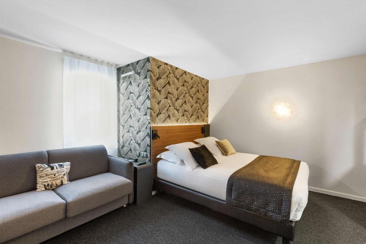 une chambre d'hôtel avec un lit et un canapé dans l'établissement Best Western Plus Europe Hôtel Brest, à Brest