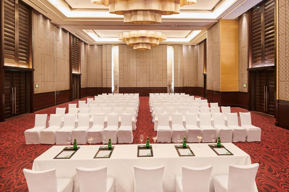 a banquet hall with white tables and white chairs at Holiday Inn Mumbai International Airport by IHG in Mumbai