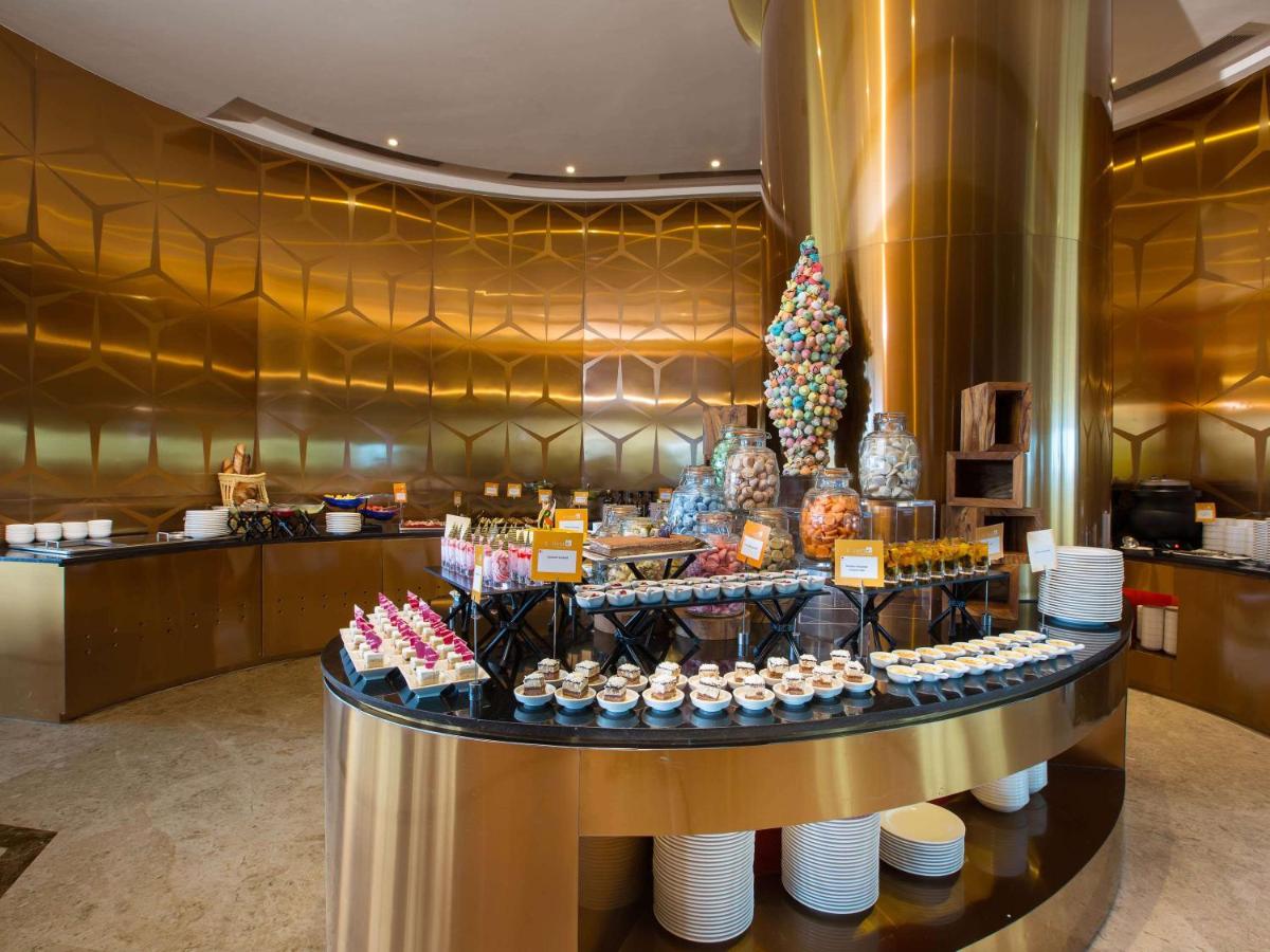 a dessert counter with a christmas tree in a lobby at Novotel Chennai Sipcot in Chennai