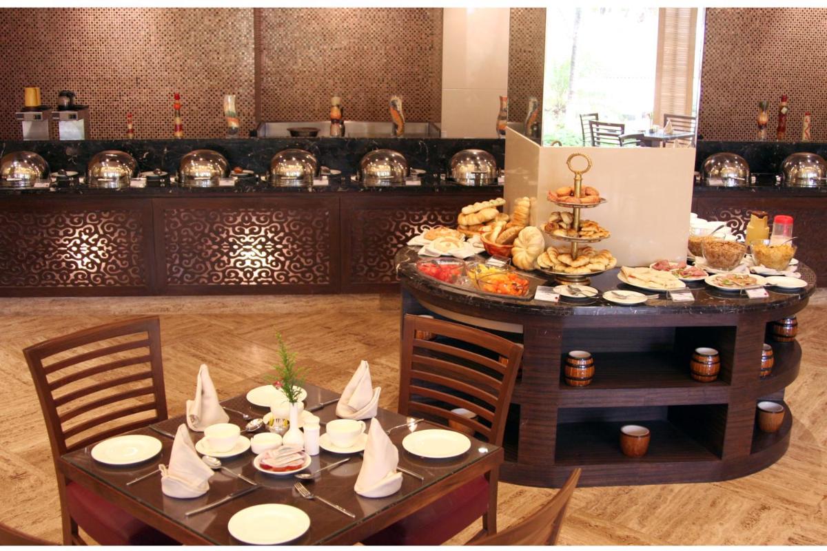 a table with plates of food on top of it at The Retreat Hotel & Convention Centre in Mumbai