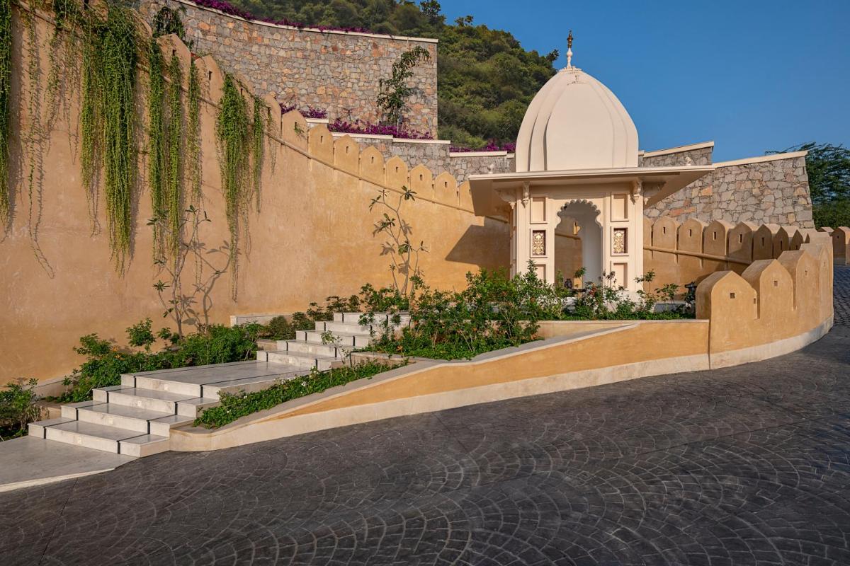 a building with stairs and a small chapel on a wall at Aurika, Udaipur - Luxury by Lemon Tree Hotels in Udaipur