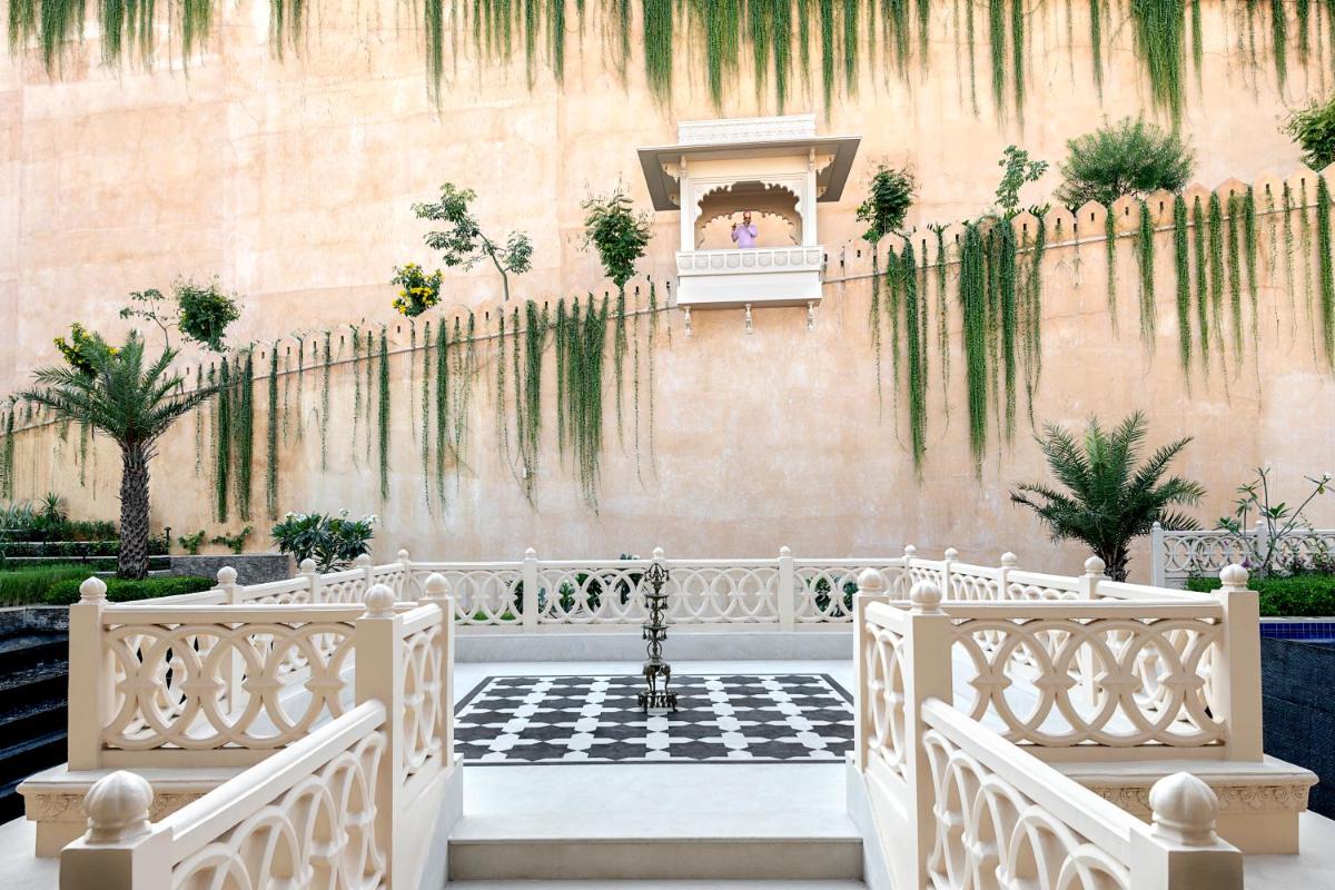a wedding ceremony in a courtyard with a wall with plants at Aurika, Udaipur - Luxury by Lemon Tree Hotels in Udaipur
