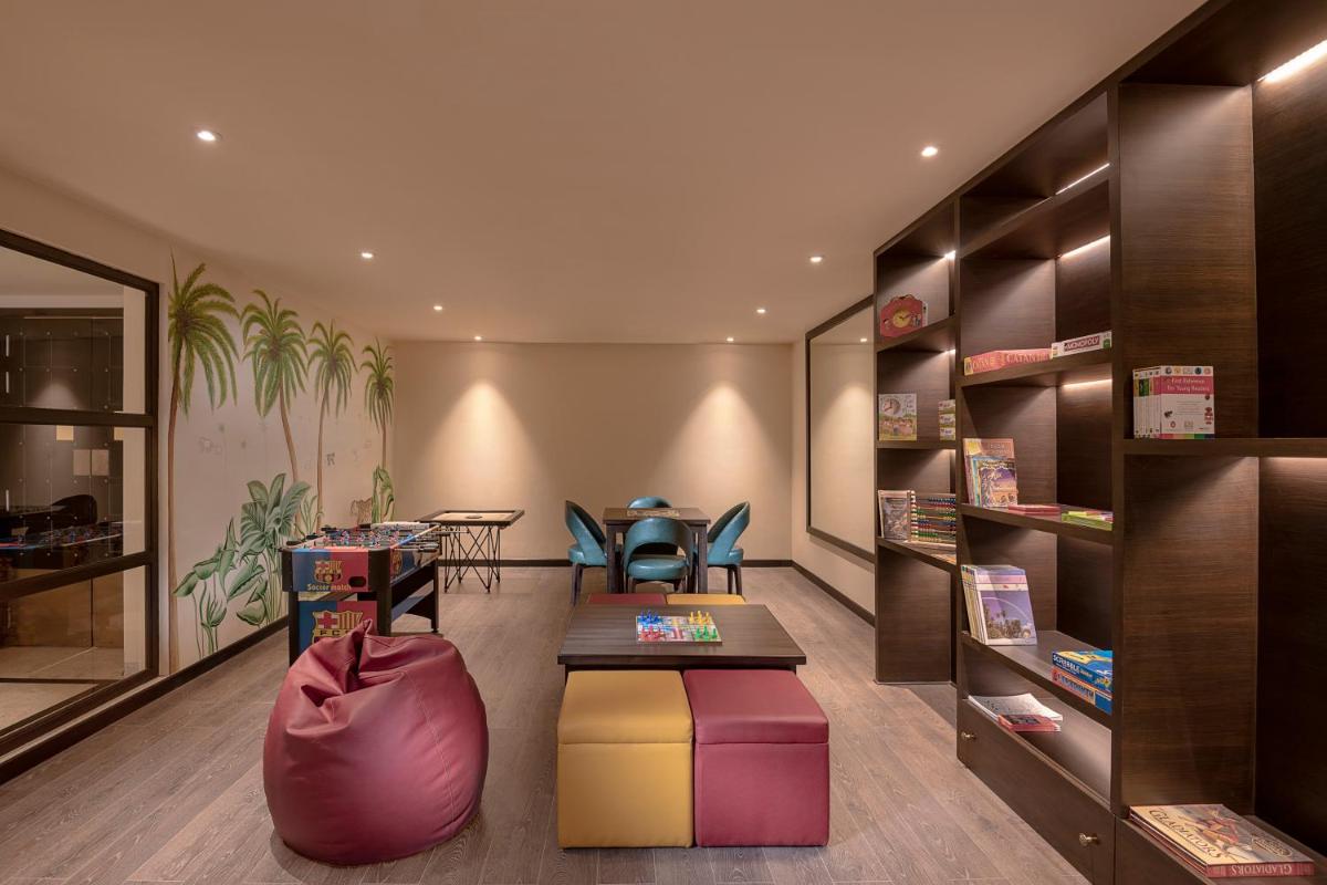 a library with a table and chairs in a room at Aurika, Udaipur - Luxury by Lemon Tree Hotels in Udaipur