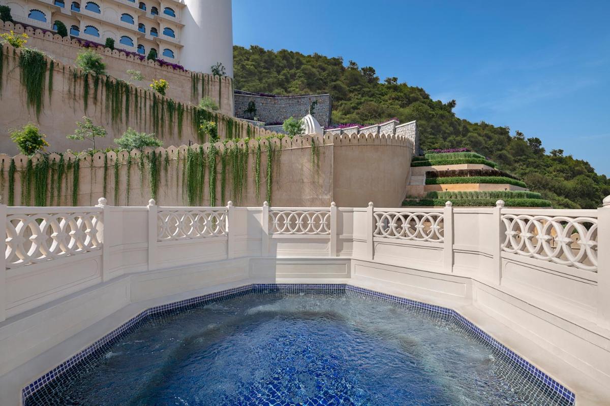 a swimming pool in a balcony with a fence at Aurika, Udaipur - Luxury by Lemon Tree Hotels in Udaipur