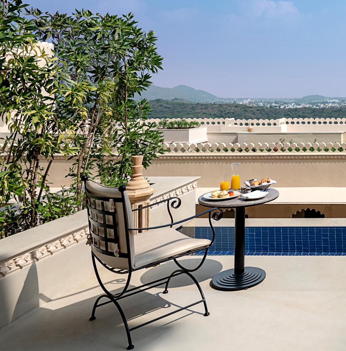 a chair and a table on a balcony at Aurika, Udaipur - Luxury by Lemon Tree Hotels in Udaipur