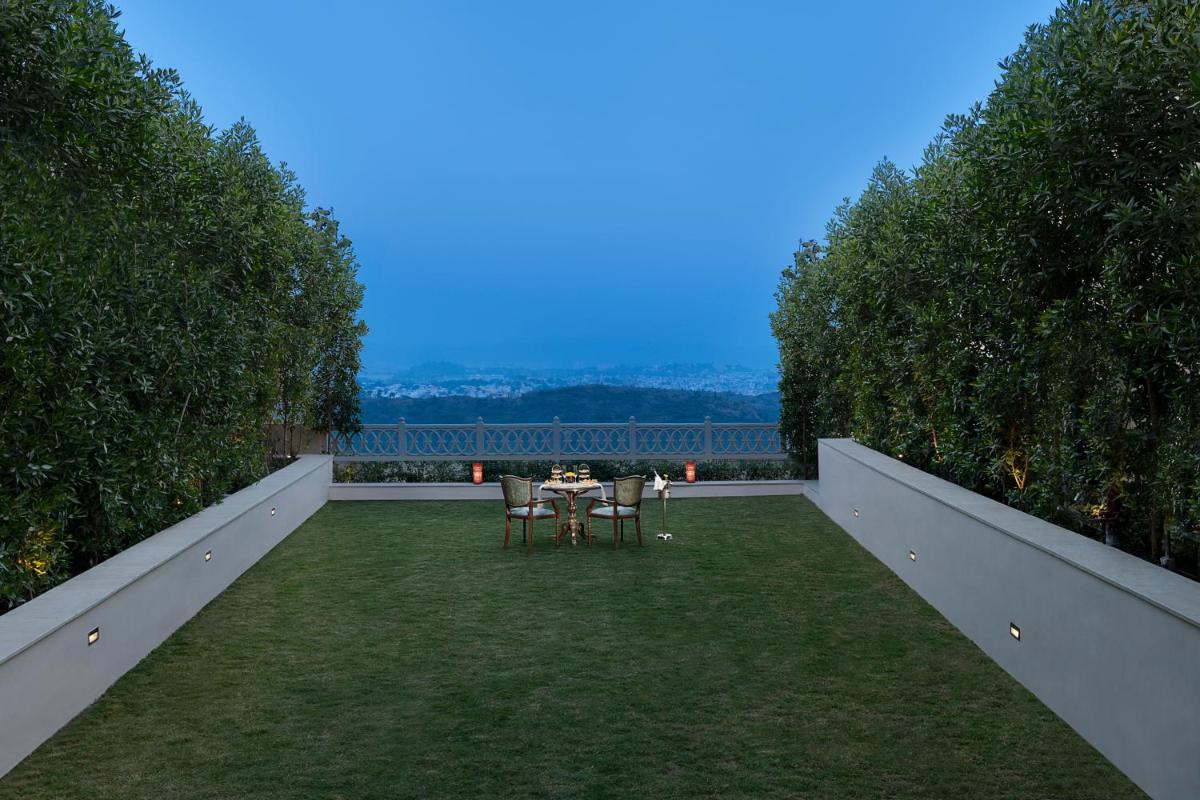 a garden with a table and chairs on a lawn at Aurika, Udaipur - Luxury by Lemon Tree Hotels in Udaipur