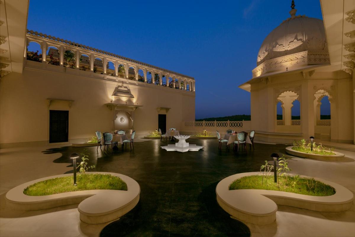 a room with a building with tables and chairs at Aurika, Udaipur - Luxury by Lemon Tree Hotels in Udaipur