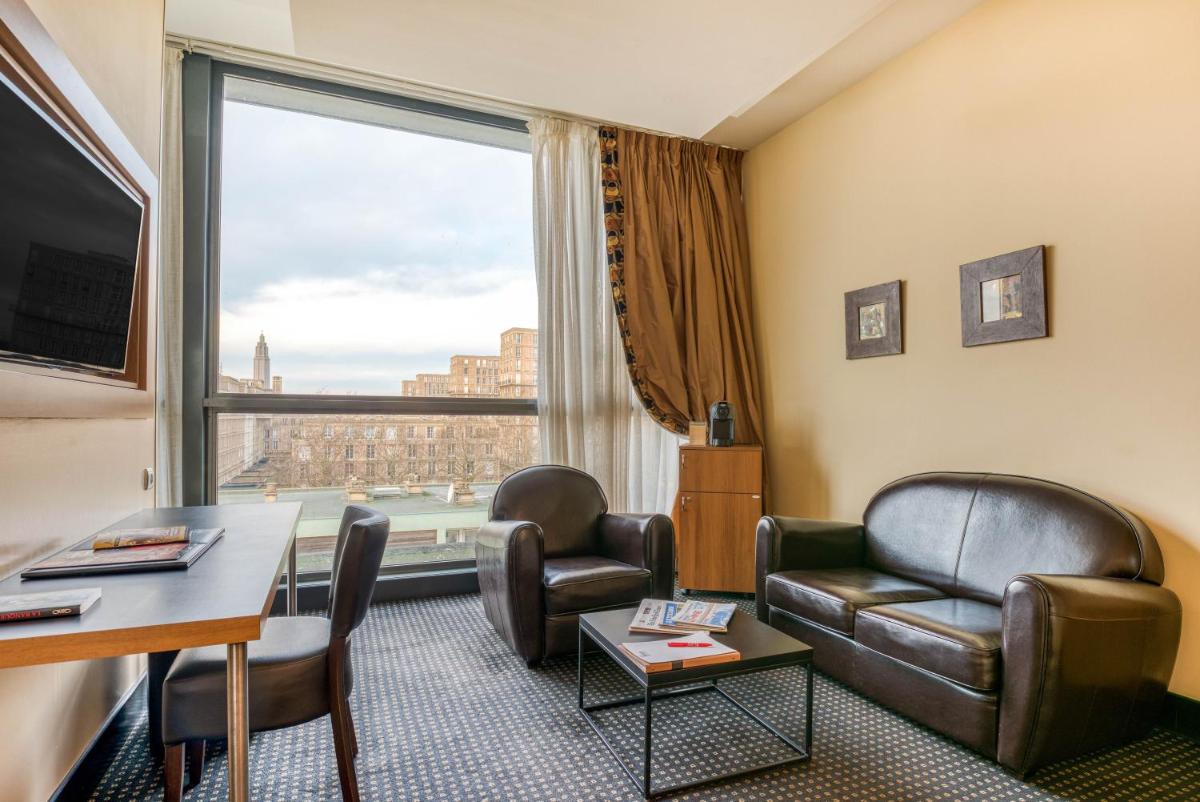 Cette chambre d'hôtel dispose de chaises, d'une table et d'une grande fenêtre. dans l'établissement Hotel Spa Le Pasino, au Havre
