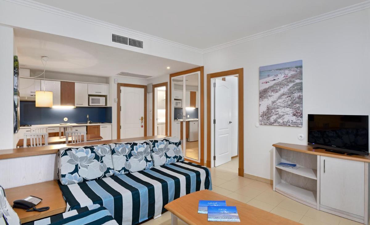 Una sala de estar con un sofá y una cocina. en Aparthotel Isla de Cabrera, en Colonia de Sant Jordi