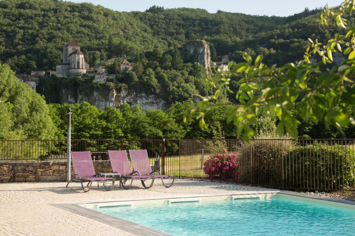 - deux chaises assises à côté de la piscine dans l'établissement Hôtel-Spa Le Saint Cirq, à Tour-de-Faure