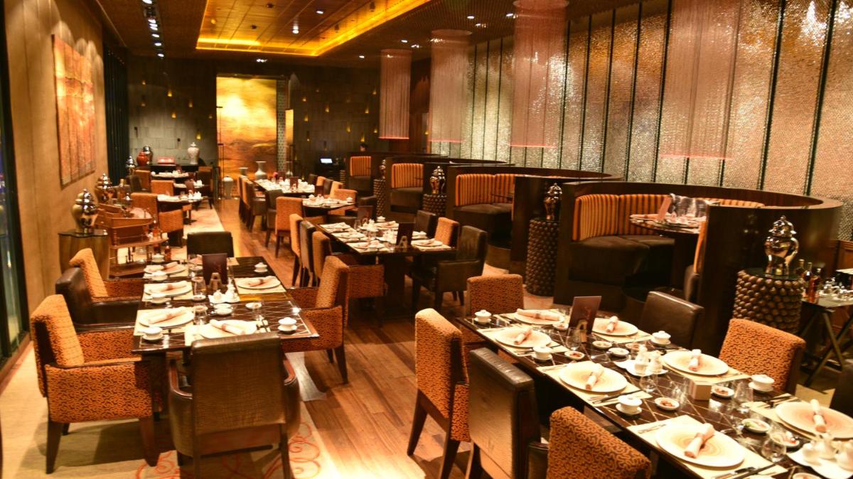 a dining room with tables and chairs in a restaurant at Taj Palace, New Delhi in New Delhi a dining room with tables and chairs in a restaurant at Taj Palace, New Delhi in New Delhi