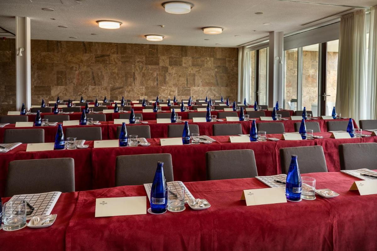 una sala de conferencias con mesas y sillas con mantel rojo en Parador de El Saler, en El Saler