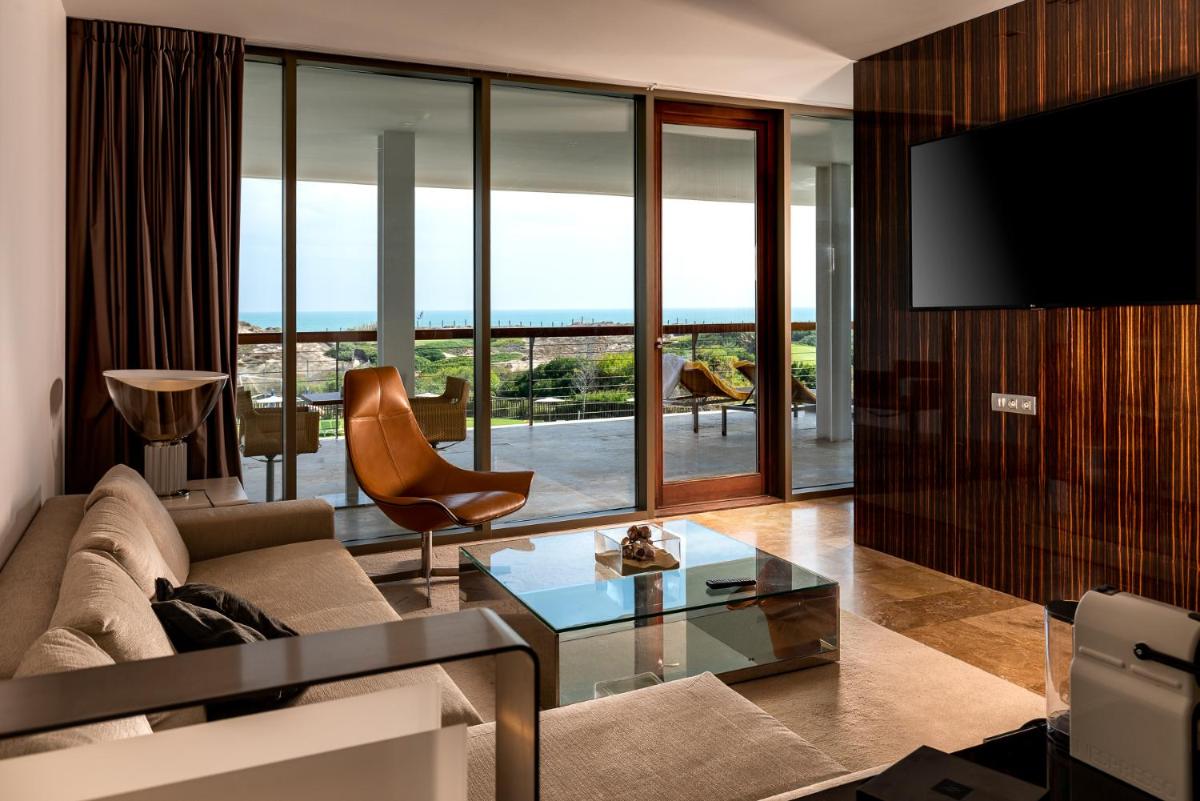 Una sala de estar con un sofá y un televisor. en Parador de El Saler, en El Saler