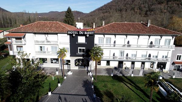 - un grand bâtiment blanc avec un panneau indiquant qu'il est interdit d'organiser des fêtes à l'hôtel dans l'établissement Hôtel du Barry Resort & Spa, à Sauveterre