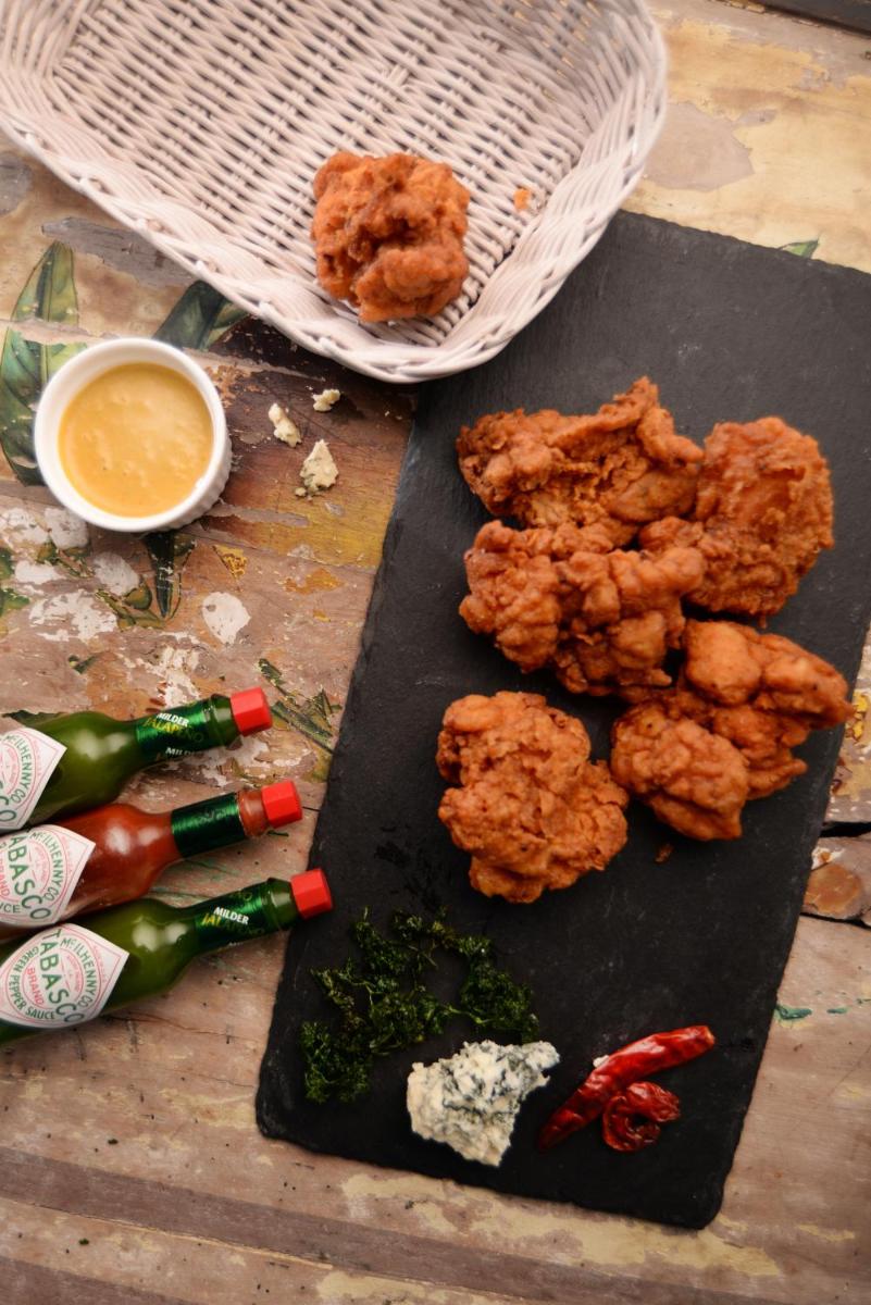 a cutting board with fried chicken and vegetables and dipping sauce at Taj Palace, New Delhi in New Delhi a cutting board with fried chicken and vegetables and dipping sauce at Taj Palace, New Delhi in New Delhi