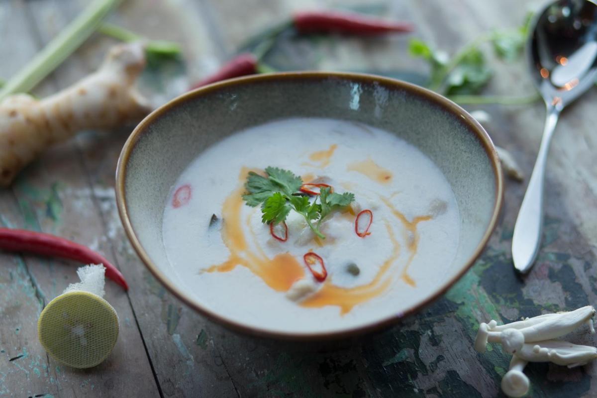 a bowl of soup on a wooden table at Taj Palace, New Delhi in New Delhi a bowl of soup on a wooden table at Taj Palace, New Delhi in New Delhi