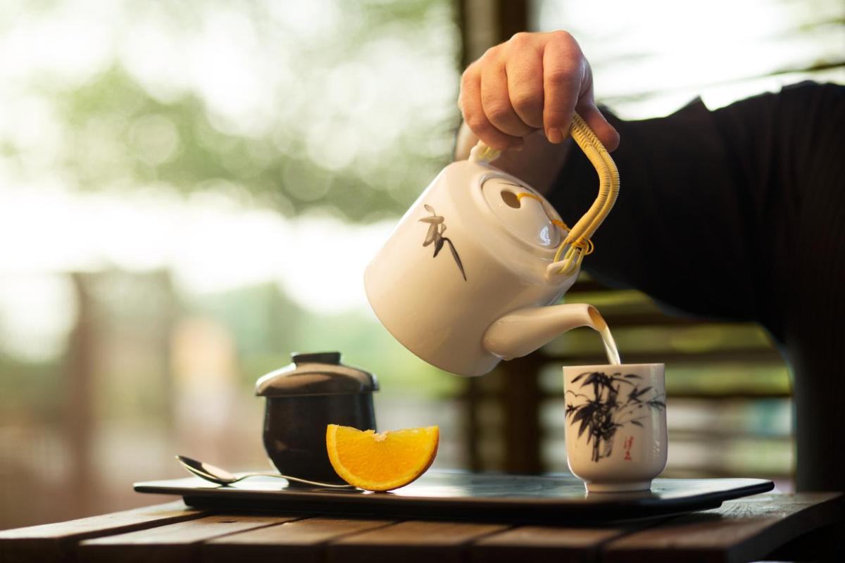 a person pouring tea from a teapot into a cup at Taj Palace, New Delhi in New Delhi a person pouring tea from a teapot into a cup at Taj Palace, New Delhi in New Delhi