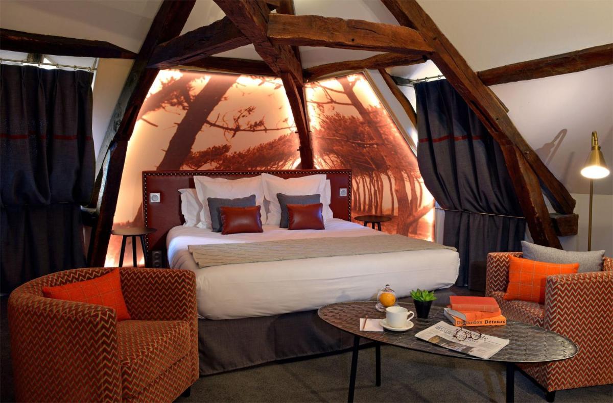 une chambre avec un lit, deux chaises et une table dans l'établissement Le Général d'Elbée Hotel & Spa - Teritoria, à Noirmoutier-en-l'lle