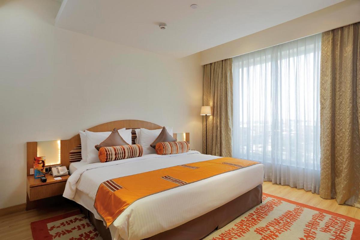 a bedroom with a large bed and a large window at Yashail Hotel Haridwar in Haridwār