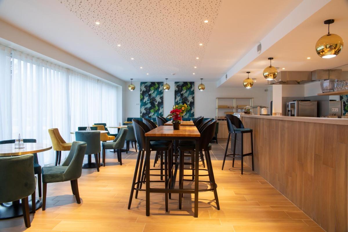 un restaurant avec un bar avec des chaises et des tables dans l'établissement Brame de Sologne, à Muides-sur-Loire