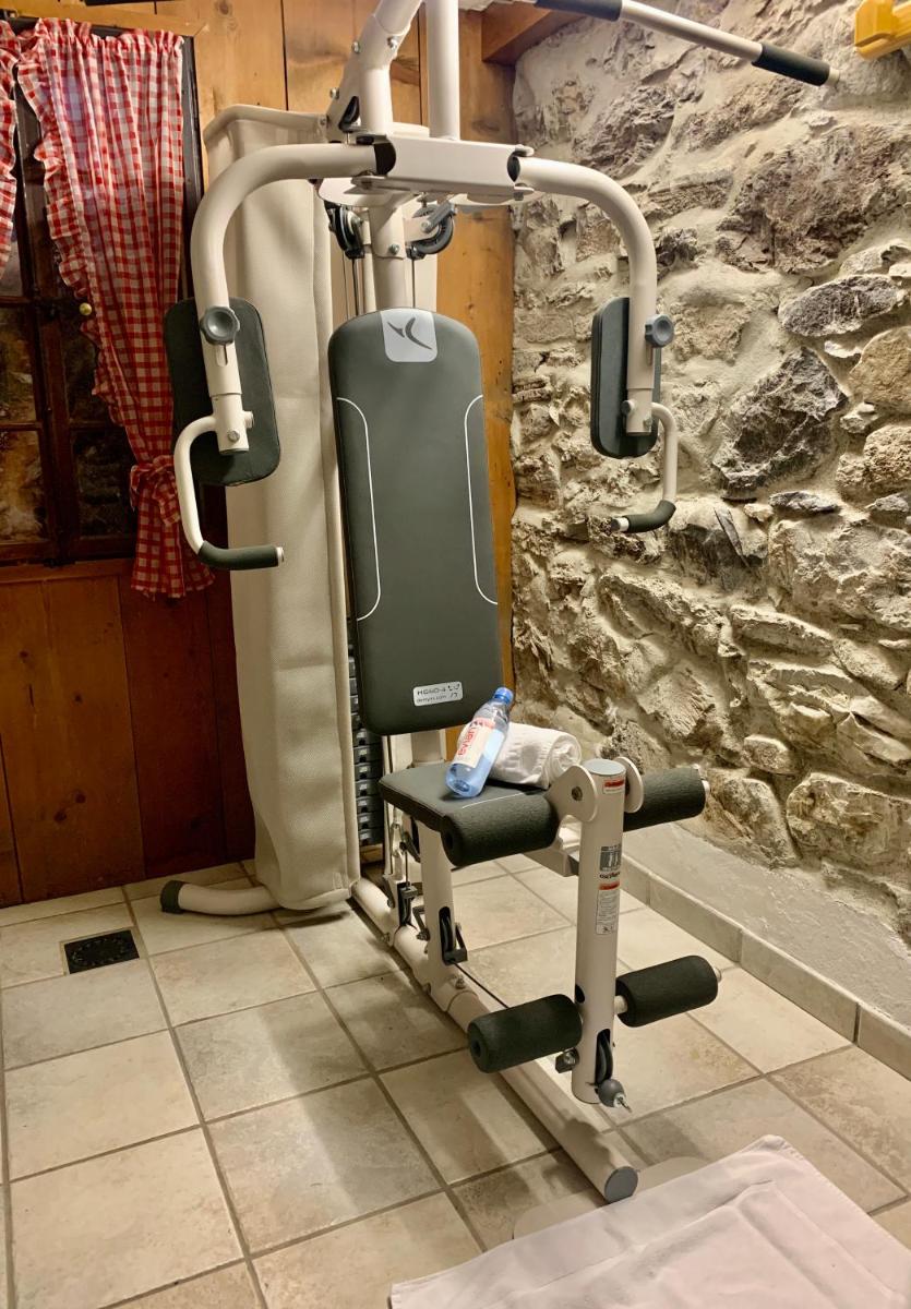 - une salle de sport avec une chaise dans l'établissement Hameau des Prodains - Hôtel, à Morzine