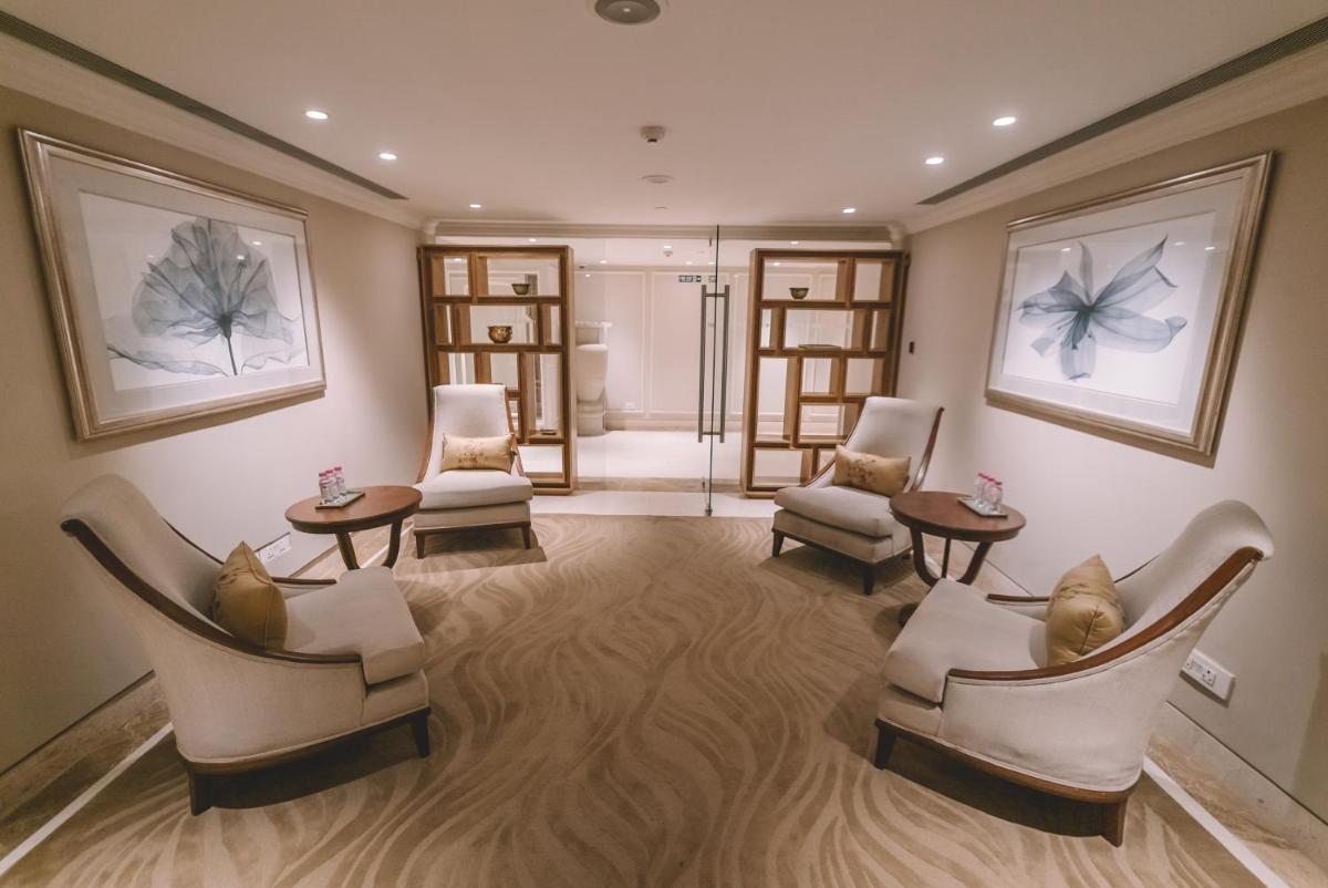 a waiting room with chairs and tables and paintings at Taj Palace, New Delhi in New Delhi a waiting room with chairs and tables and paintings at Taj Palace, New Delhi in New Delhi