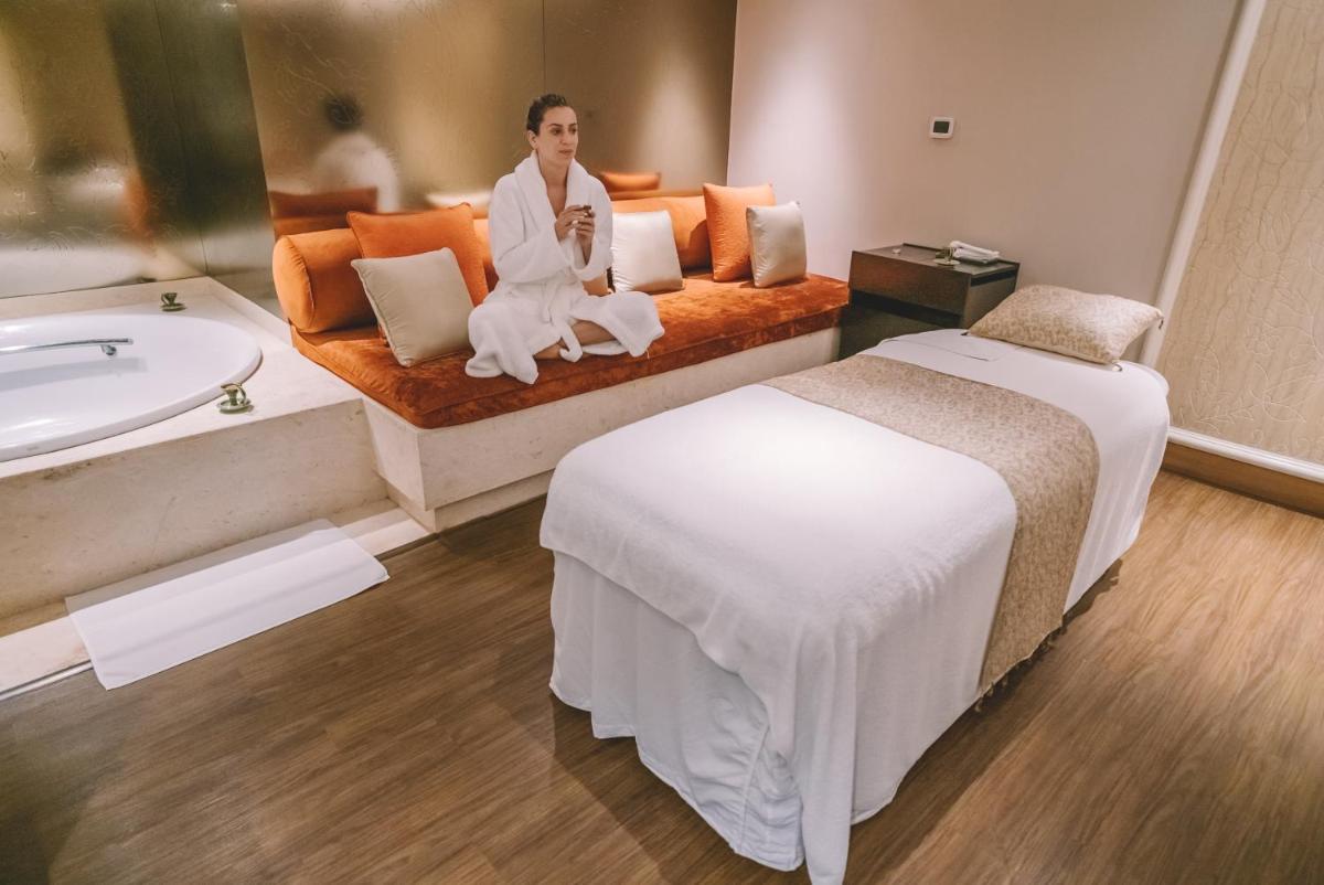 a man sitting on a bed in a hotel room at Taj Palace, New Delhi in New Delhi a man sitting on a bed in a hotel room at Taj Palace, New Delhi in New Delhi