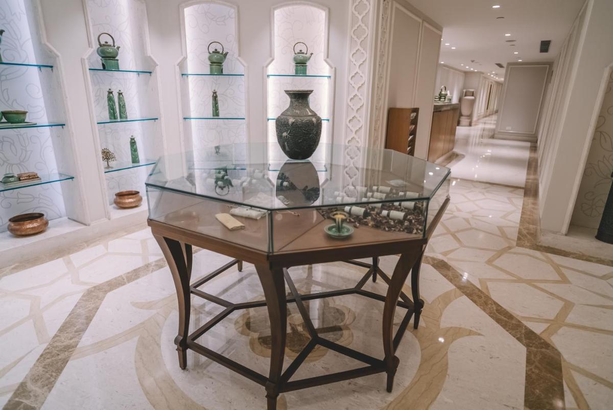 a glass table in a room with vases on shelves at Taj Palace, New Delhi in New Delhi a glass table in a room with vases on shelves at Taj Palace, New Delhi in New Delhi