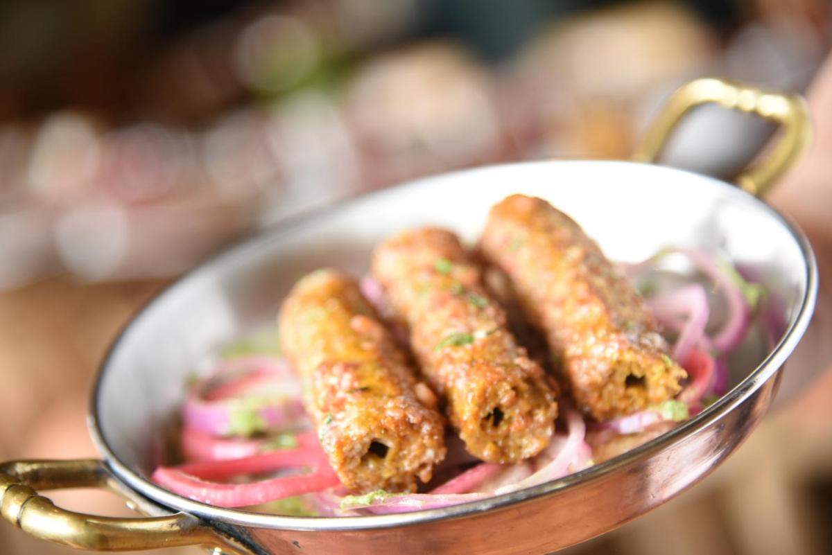 a metal bowl of food with sausages and onions at Taj Palace, New Delhi in New Delhi a metal bowl of food with sausages and onions at Taj Palace, New Delhi in New Delhi