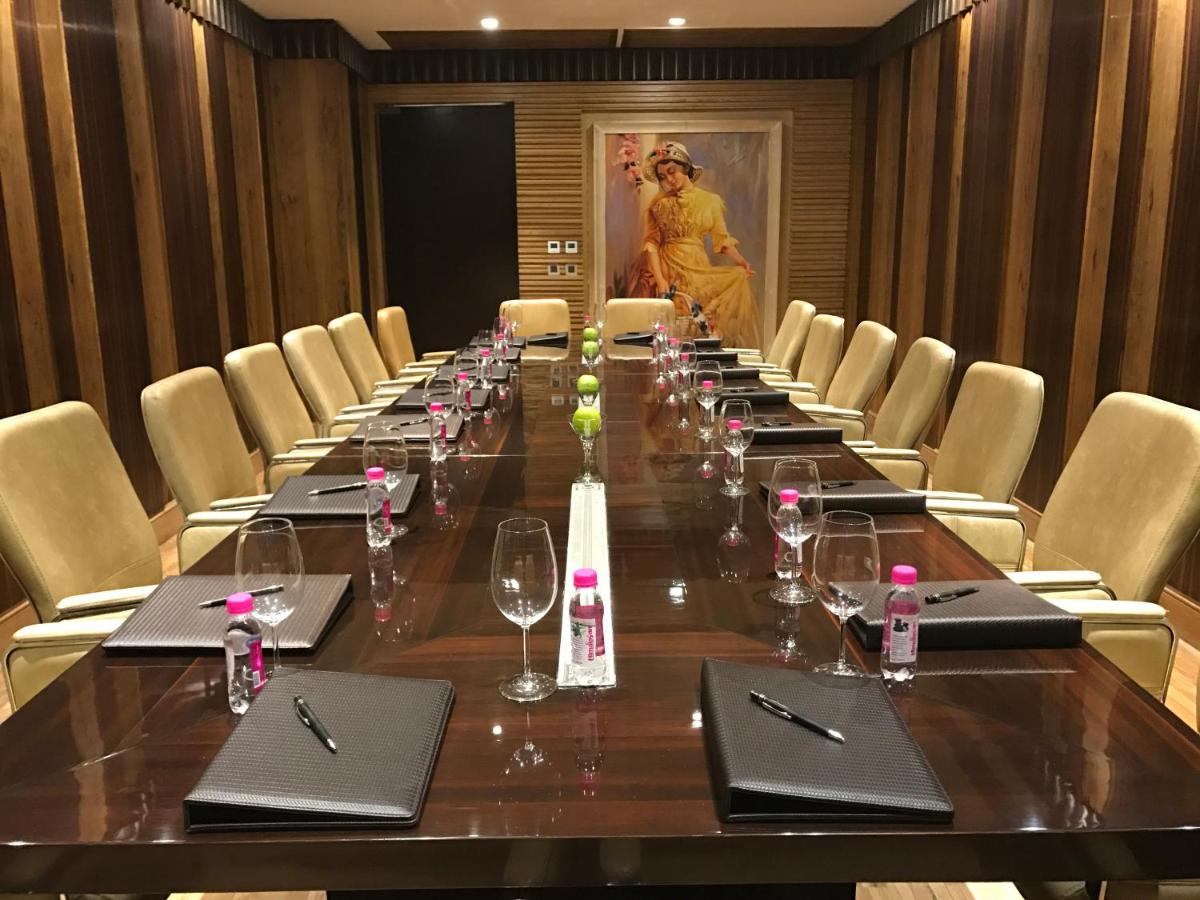 a long table in a conference room with chairs at Seven Seas Hotel in New Delhi