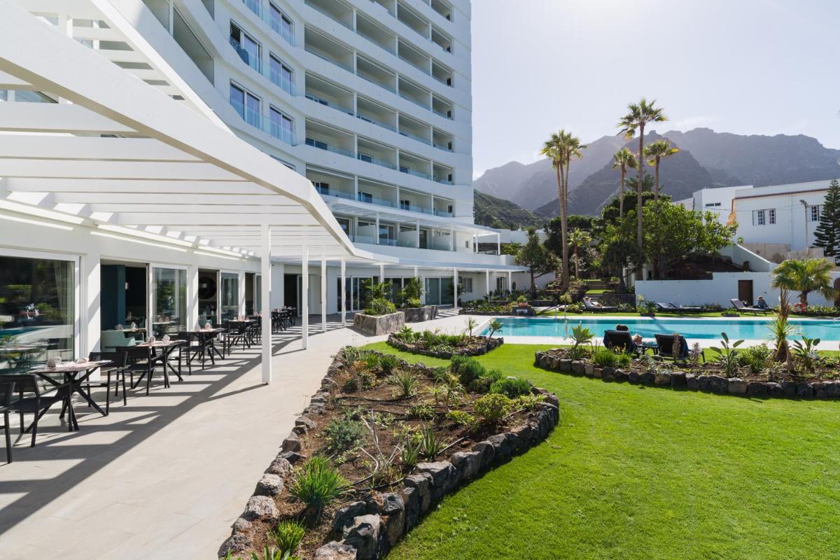 una vista exterior de un hotel con mesas y sillas en OCEANO Health Spa Hotel, en Punta del Hidalgo